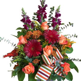Bouquet of orange roses, red gerberas, and purple snapdragons in a wooden box