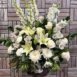 White floral arrangement with lilies, roses, and chrysanthemums in a vase