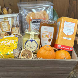 Gift basket with tea, honey, biscuits, lemon curd, and oranges