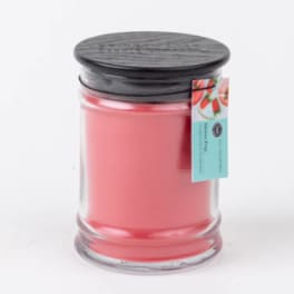 Pink candle in a clear glass jar with a black lid