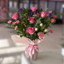 Pink roses and small mixed flowers in a wrapped vase arrangement