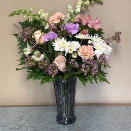 Mixed pastel bouquet in a tall dark vase