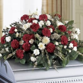Red and white carnation casket spray with greenery