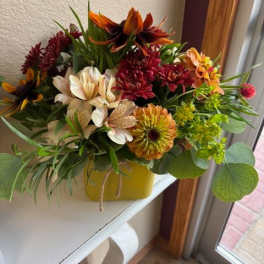 Mixed bouquet of chrysanthemums and alstroemeria in a yellow container