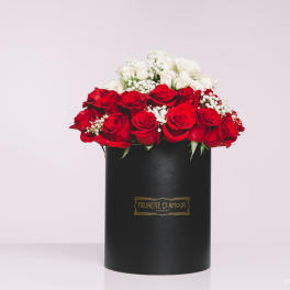 Red and white roses arranged in a black hat box