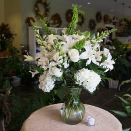 White floral arrangement in a glass vase on a table