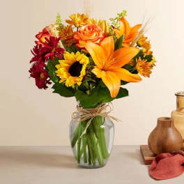 Orange and yellow mixed bouquet in a clear glass vase