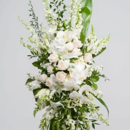 Tall white floral standing arrangement with roses and orchids