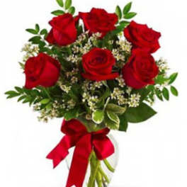 Bouquet of red roses with greenery in a clear glass vase