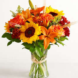 Bouquet of orange and yellow flowers in a clear glass vase