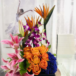 Tall tropical bouquet with orange roses, pink lilies, and purple orchids