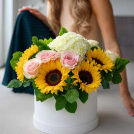 Bouquet of sunflowers, pink roses, and white hydrangea in a white hat box