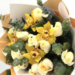 Bouquet of yellow orchids and cream roses with eucalyptus