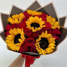 Bouquet of red roses and yellow sunflowers wrapped in dark paper