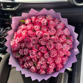 Large bouquet of pink roses wrapped in lavender paper