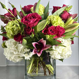 Square vase arrangement with hot pink roses, white hydrangeas, green blooms and pink lilies