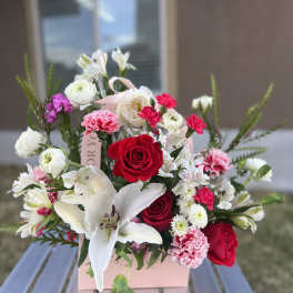 Bouquet of red and white flowers in a pink gift box