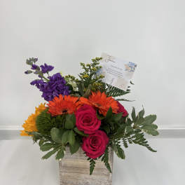 Mixed bouquet in a wooden box with pink roses and orange gerberas