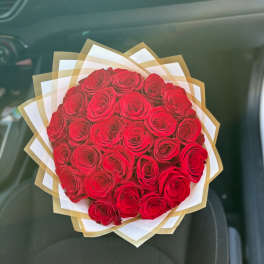 Bouquet of red roses wrapped in white and gold paper