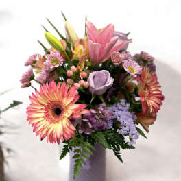 Mixed bouquet in a lavender vase with pink and purple flowers