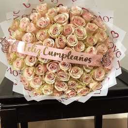 Large bouquet of pale peach roses with a "Feliz Cumpleaños" ribbon