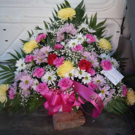 Large mixed flower spray with pink ribbon and red roses