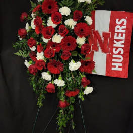 Red and white floral standing spray with a Nebraska Huskers flag