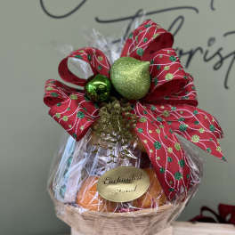 Gift basket wrapped in clear cellophane with a red holiday bow
