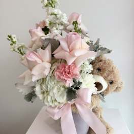 Pink and white bouquet with a teddy bear in a vase