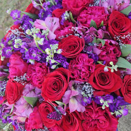 Bouquet of red and pink roses with purple flowers and butterfly accents
