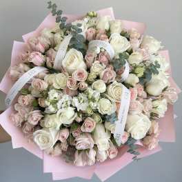 Large bouquet of white and blush roses wrapped in pink paper
