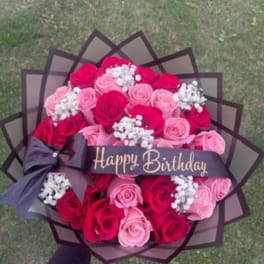 Bouquet of pink and red roses with a Happy Birthday ribbon