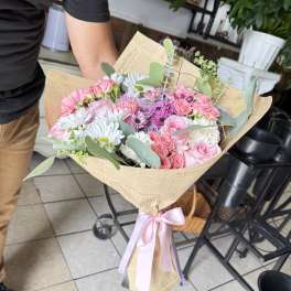 Pink and white mixed bouquet wrapped in paper with a ribbon