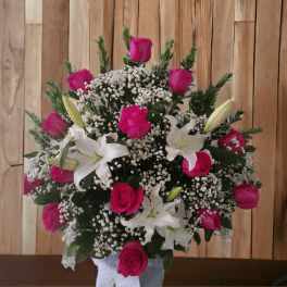 Pink roses and white lilies in a vase with baby's breath