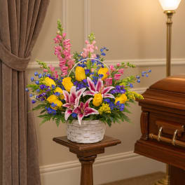 Colorful funeral basket with lilies, roses, and snapdragons