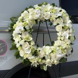 White floral wreath on a black stand