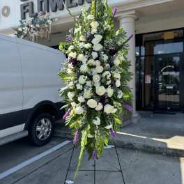 Tall white and purple floral standing spray on an easel