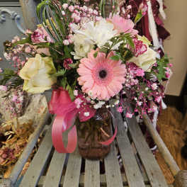 Pink and white mixed bouquet in a glass vase with a ribbon