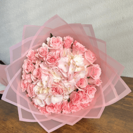 Pink rose bouquet wrapped in translucent pink paper