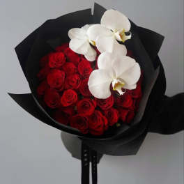 Bouquet of red roses with white orchids wrapped in black paper