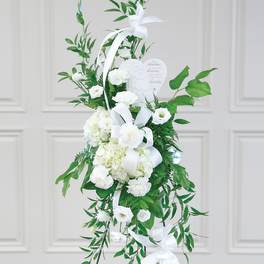 White sympathy standing spray with ribbon and heart plaque