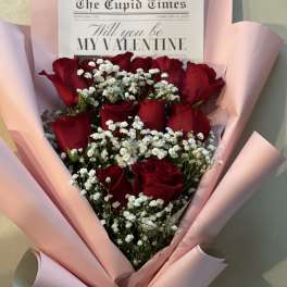 Bouquet of red roses with white baby's breath in pink wrapping