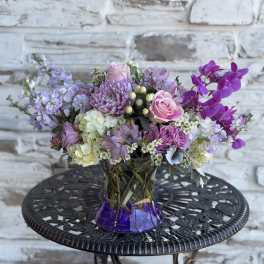 Lavender and pink bouquet in a purple glass vase