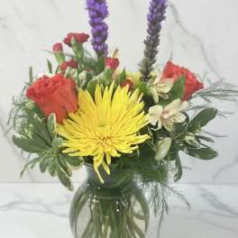 Bouquet of yellow and red flowers in a glass vase