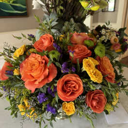 Bright mixed bouquet with orange and yellow roses in a vase