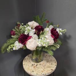 Bouquet of white and deep pink flowers in a faceted metallic vase