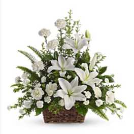 White lilies and carnations arranged in a wicker basket