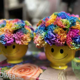 Rainbow flower arrangements in yellow smiley-face mugs