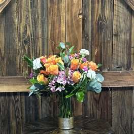 Bouquet of orange and yellow roses in a metal vase