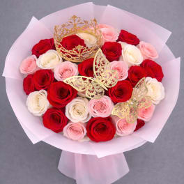 Bouquet of red, pink, and white roses with gold crown and butterfly accents